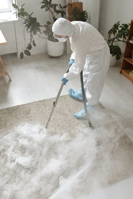 A low-angle view of a clean, plush grey carpet running through a hallway in a residential property, with white wooden paneling on the walls, decorative trim, and multiple doors on either side. The hal